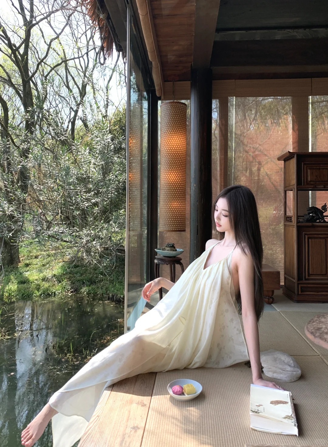 穿浅色长裙的女性坐在窗边
